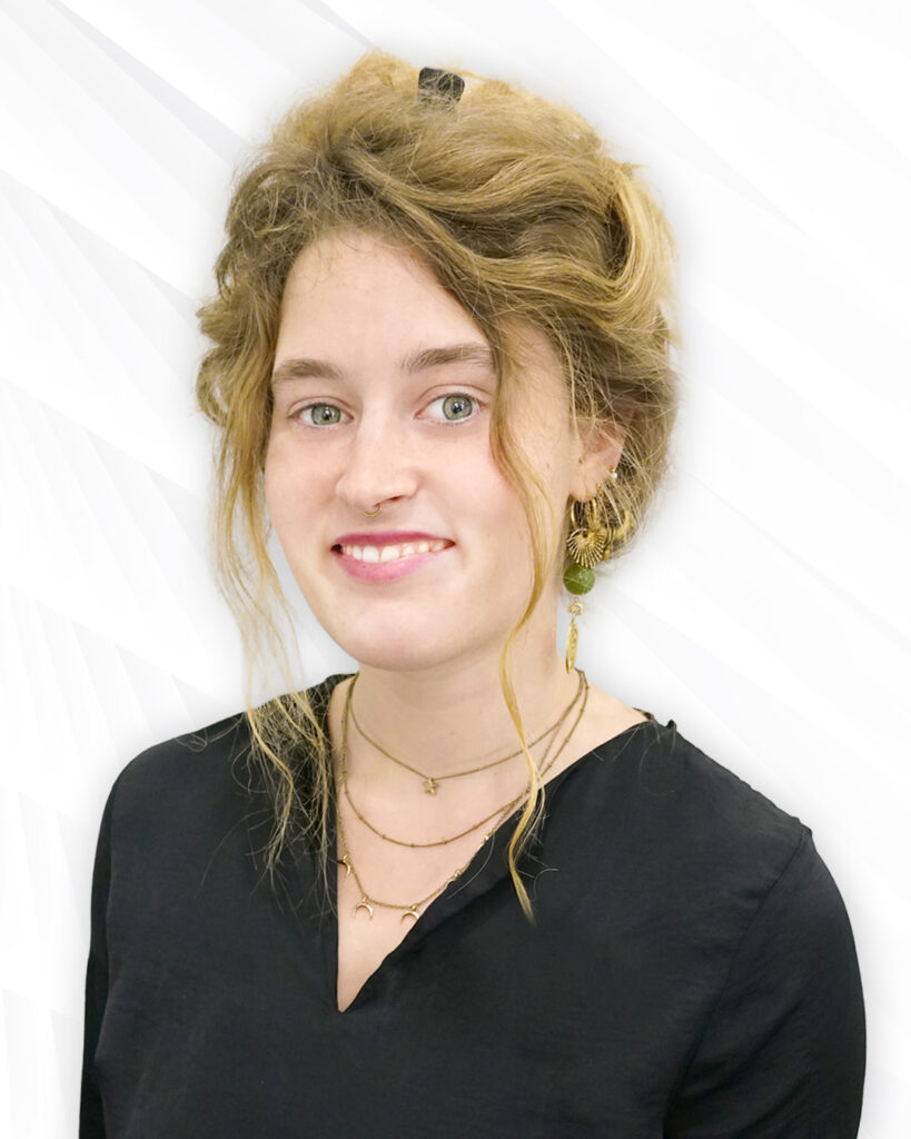 Augenoptikerin mit hochgestecken Haaren, Ohrringen sowie Nasenpiercing