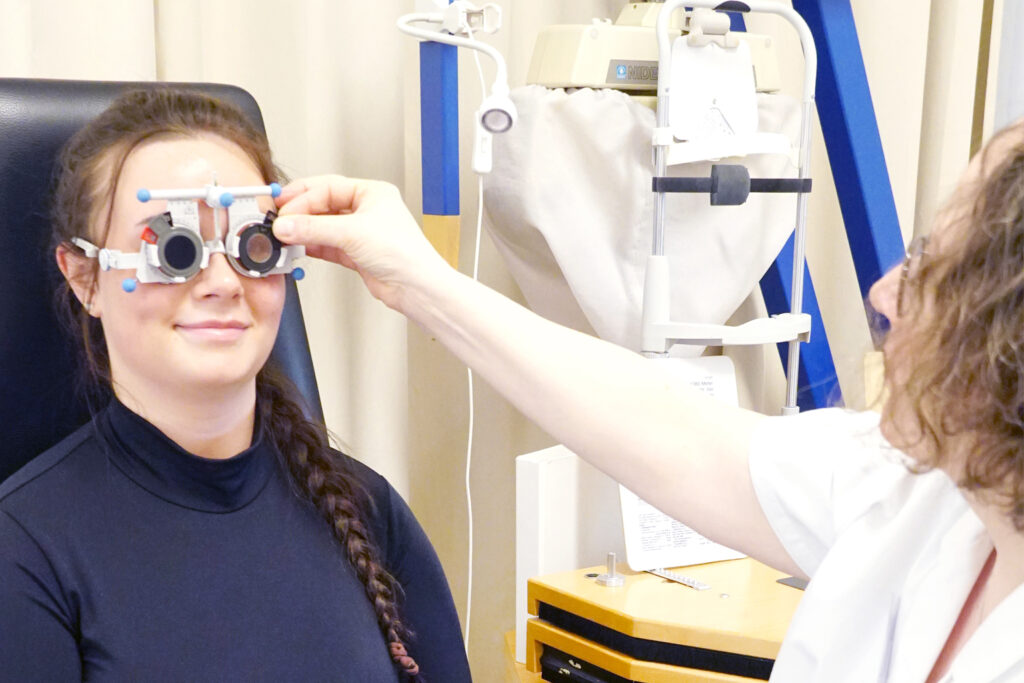Orthoptistin untersucht eine Patientin mit speziellen Brillengläsern