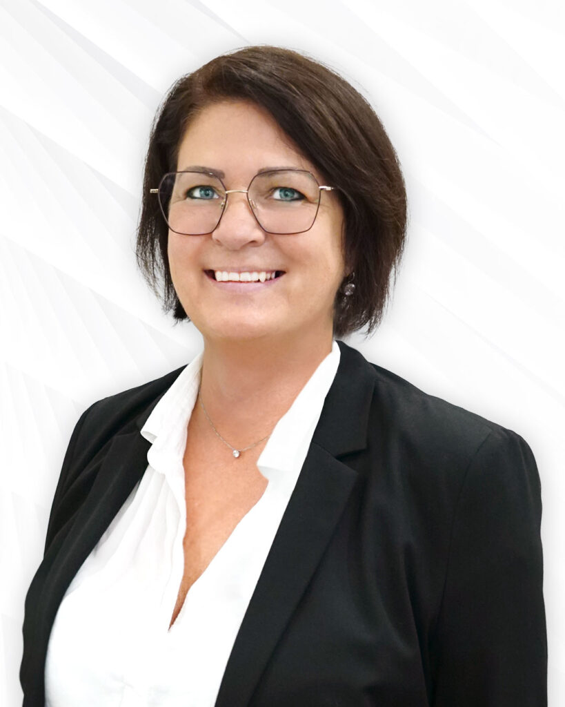 Optikmitarbeiterin in Anzug mit Brille und mittellangen Haaren, lächelnd